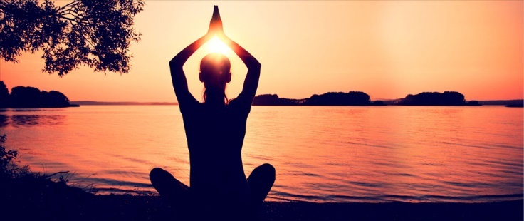 Pessoa a praticar yoga ao pôr do sol